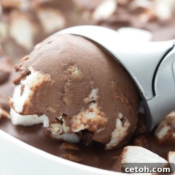 Close up shot of an ice cream scoop digging into keto rocky road ice cream.