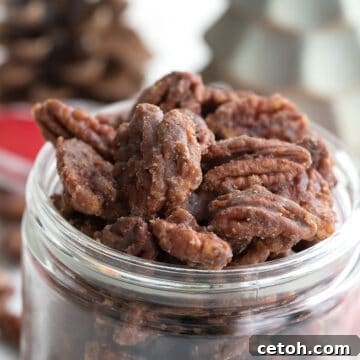 Close up shot of keto candied pecans in a glass jar.