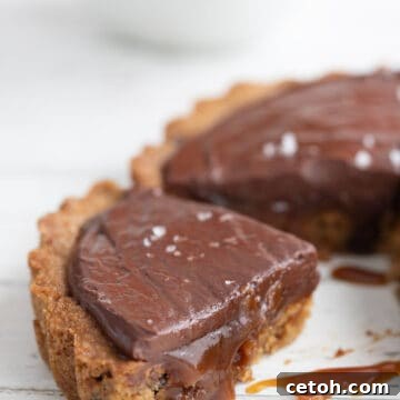 Close up shot of a slice of keto caramel tart with the caramel sauce oozing out.