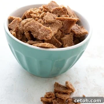 Homemade keto cereal in a large teal bowl with some pieces in front.