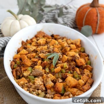 Keto Stuffing in an oval baking dish in front of pumpkins and Thanksgiving decorations.