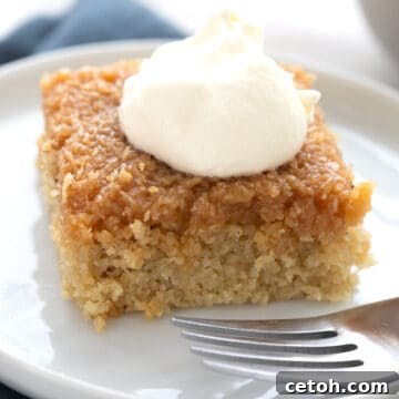 Close up shot of a slice of Keto Danish Dream Cake with whipped cream on top.