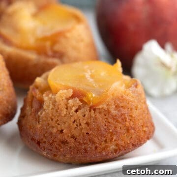 Keto Peach Upside Down Cakes on a white platter with a peach in the background.