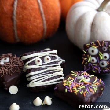 Keto Halloween Brownies decorated like mummies and monsters with pumpkins in the background.