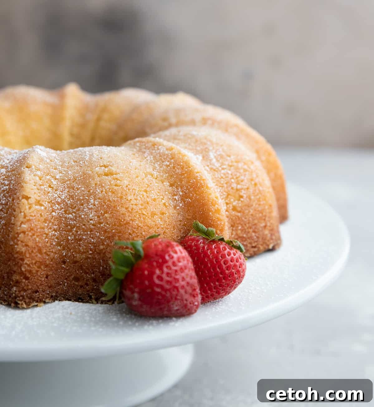 Keto Kentucky Butter Cake on a white cake plate with strawberries.
