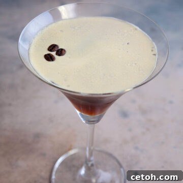 A single espresso martini on a weathered table.