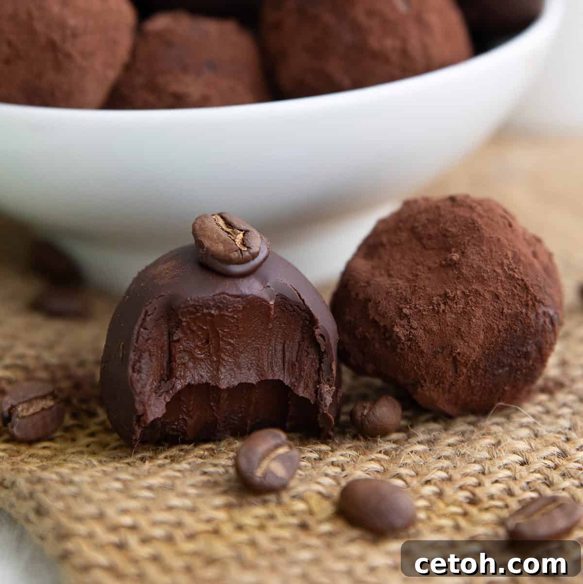Close up shot of two keto truffles on a piece of burlap with a bite taken out of one of them.
