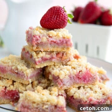 Keto strawberry rhubarb crumb bars on a white plate on a white table.