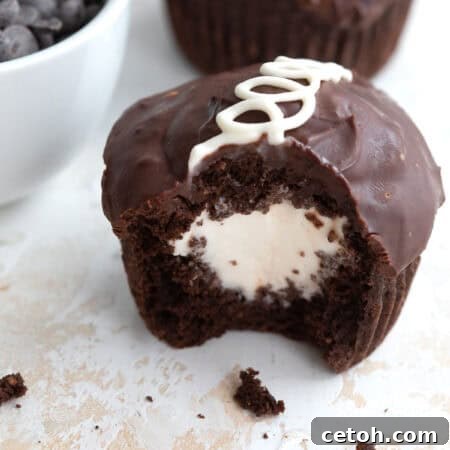 A copycat Keto Hostess Cupcake on a marble table top with a bite taken out of it and crumbs strewn around.