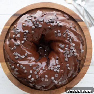 Top down image of Keto Chocolate Ricotta Cake on a wooden cake stand on a white table.