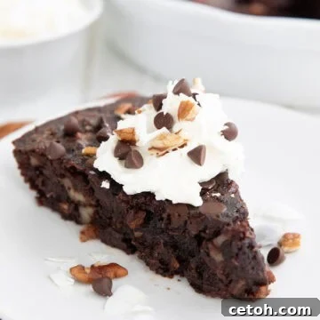 A slice of Keto German Chocolate Pie on a white plate over a dark orange napkin.