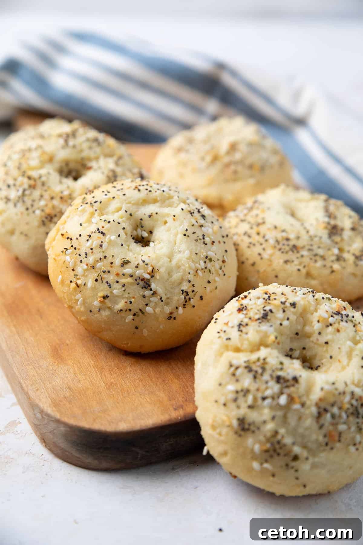Delicious cottage cheese protein bagels are artfully arranged on a wooden cutting board, ready to be enjoyed.
