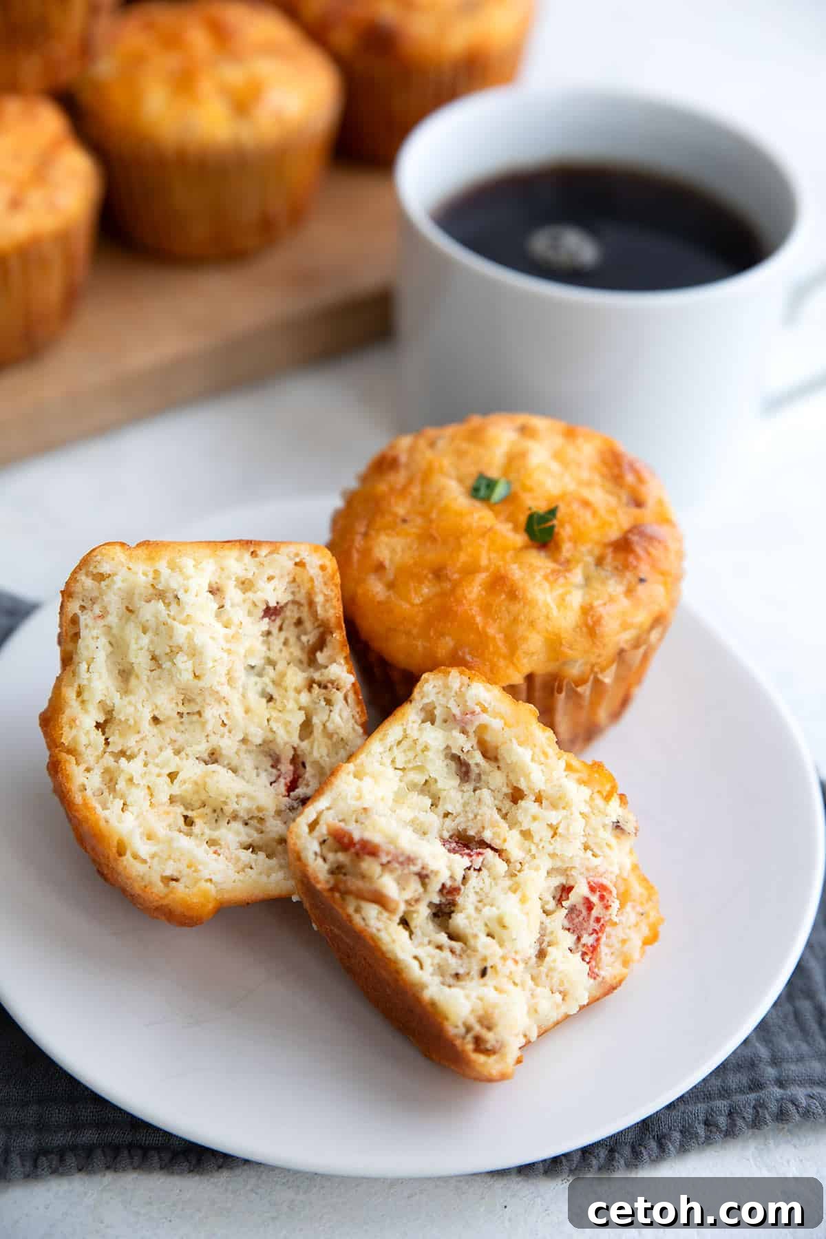 Keto Cottage Cheese Muffins displayed with one muffin broken open on a white plate, revealing its delicious interior.