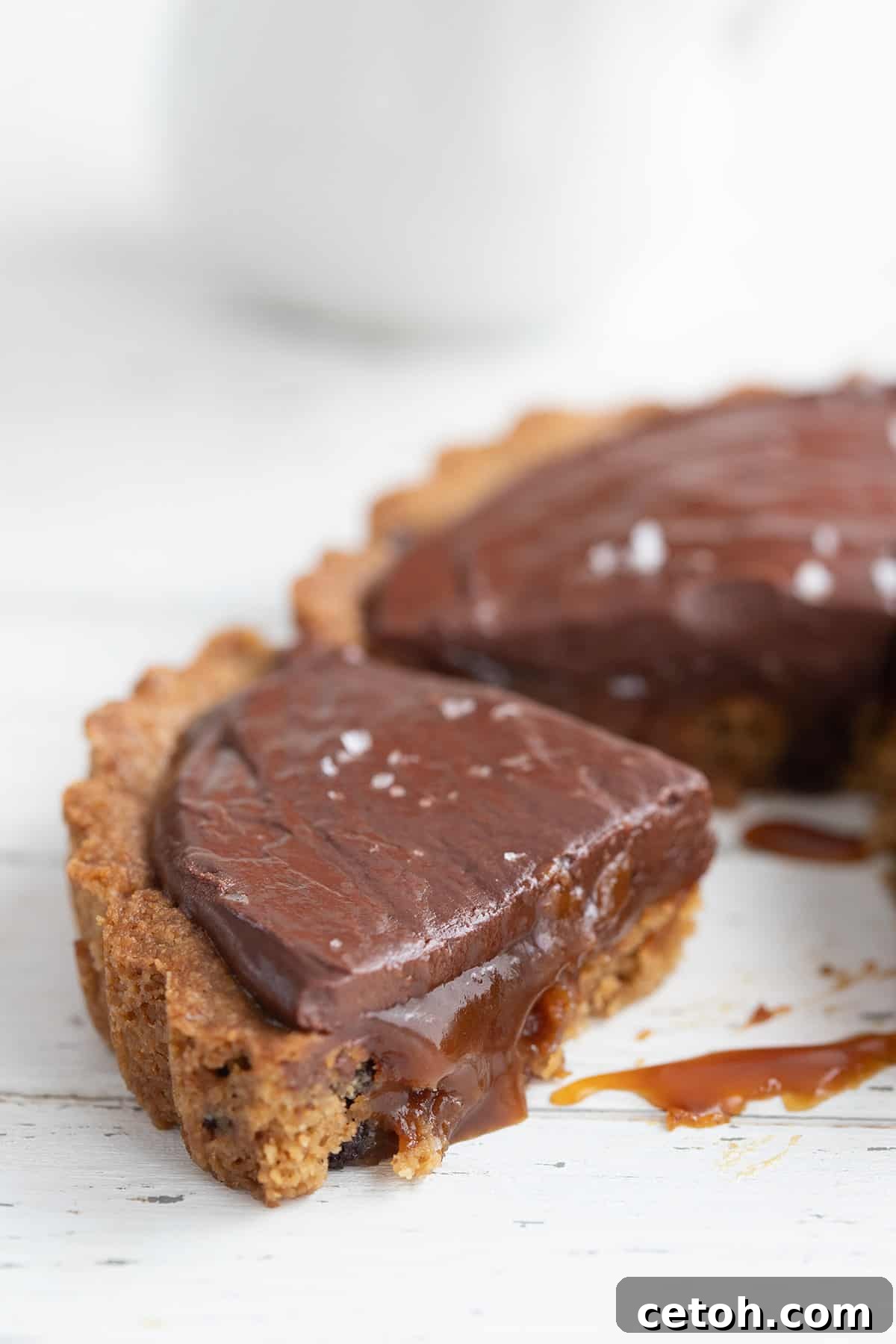 Decadent Keto Butter Tarts 4 A tempting close-up shot of a slice of keto caramel tart, showing the rich, shimmering caramel sauce gently oozing out.