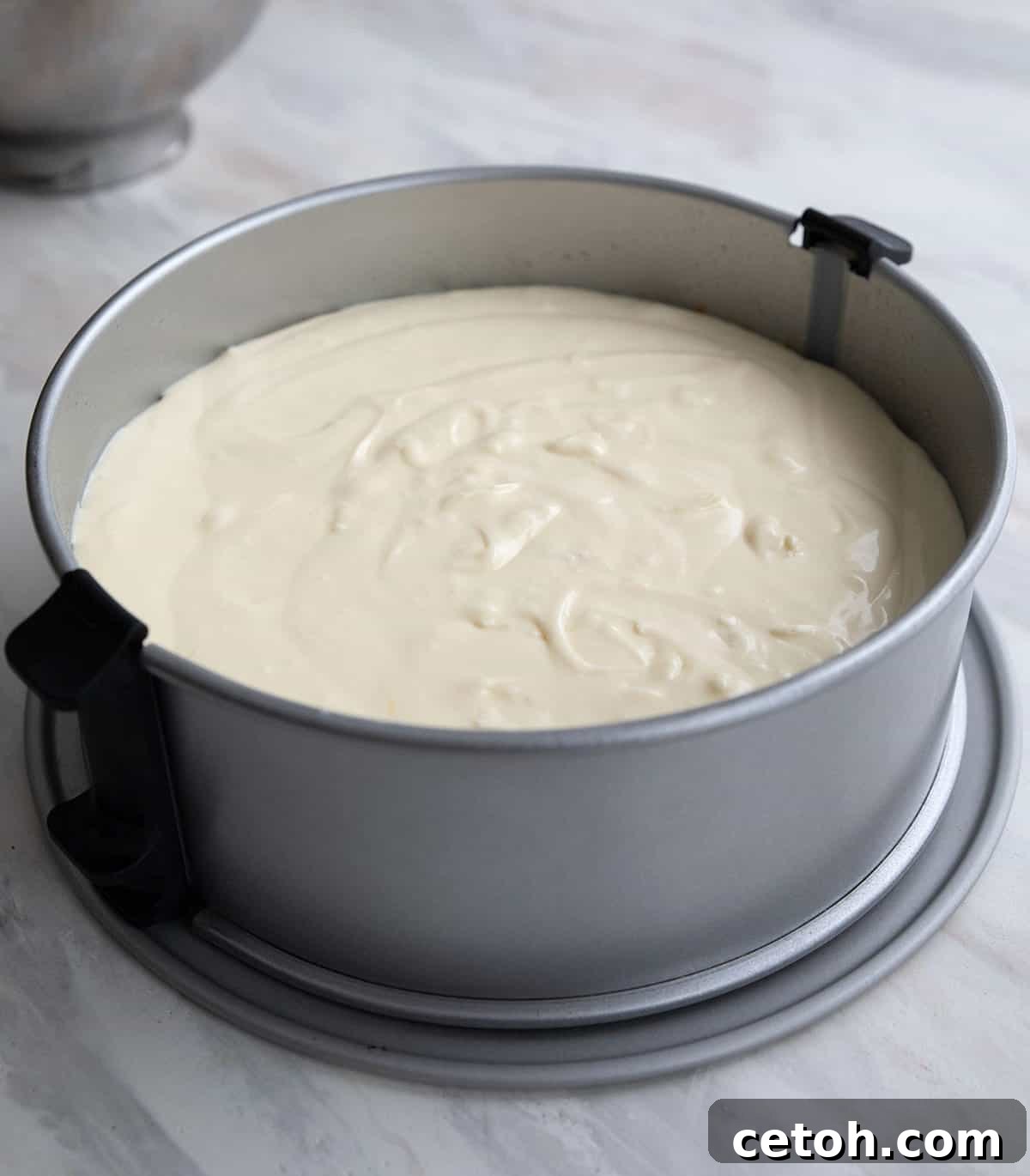 Cheesecake batter in a cheesecake pan, waiting to be baked. 