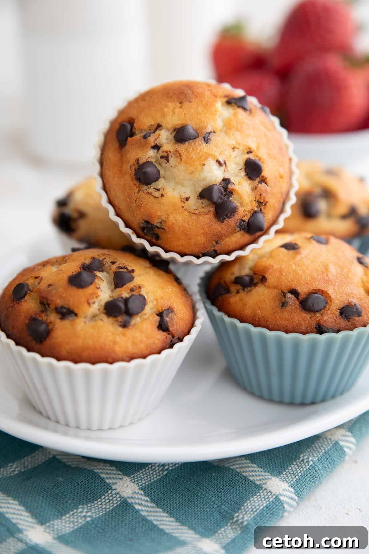 Egg-Free Muffin Perfection 2 Egg Free Muffins in silicone liners piled up on a white platter.