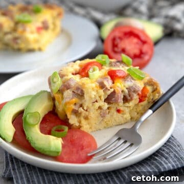 Effortless Keto Slow Cooker Breakfast Bake 5 A slice of Slow Cooker Breakfast Casserole on a white plate over a striped grey napkin.