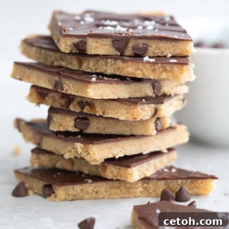 Blissful Protein Cookie Dough Bark 2 Keto Cookie Dough Protein Bark pieces in a stack on a gray table top.