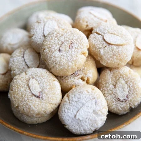 A pile of keto amaretti cookies on a rustic green plate.