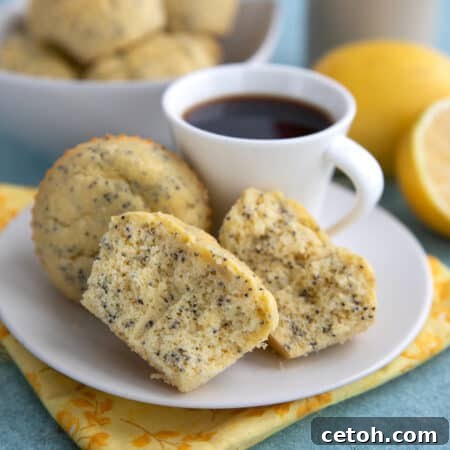 Lemon Poppyseed Protein Muffins on a white plate with a cup of coffee, over a yellow flowered napkin.