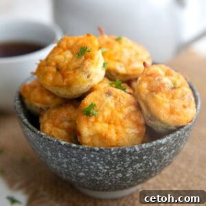 Sausage Egg and Cheese Bites piled up in a speckled gray bowl over a burlap napkin.