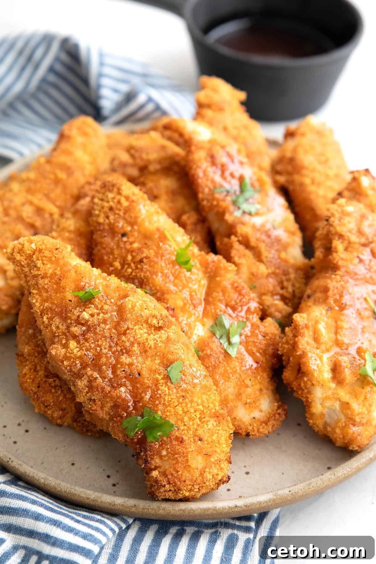 Keto Chicken Tenders on a grey plate over a blue patterned napkin.