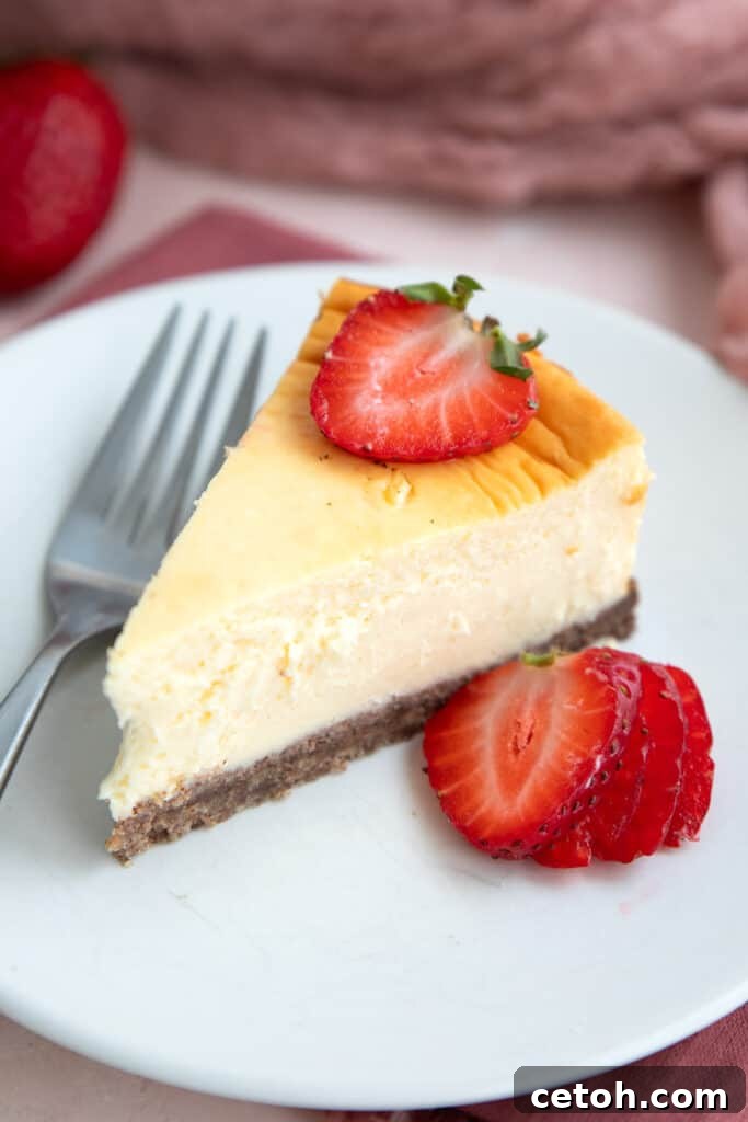 Low-Carb Keto Granola Recipe for Air Fryer (Crunchy & Fast) 9 A slice of Keto Air Fryer Cheesecake on a white plate with sliced strawberries.